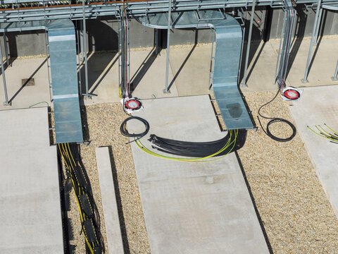 Aerial view of a data center facility featuring organized cable trays, fiber optic cabling, and concrete pads in the United Kingdom.