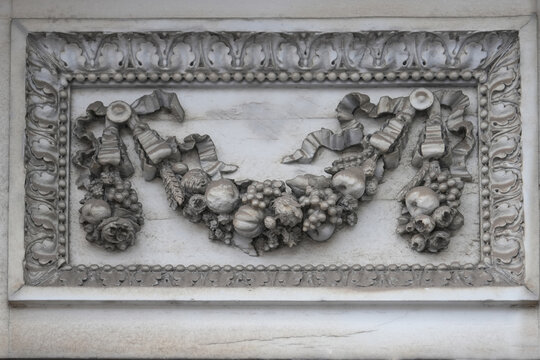 Ornate fruit floral garland with grapes pears roses and pumpkins on antique french door with carved Masqueron