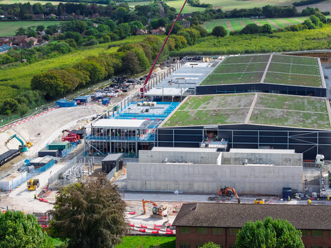 Aerial view of a large data center construction site featuring green roofs, concrete structures, and heavy machinery in the United Kingdom.