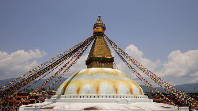 Colorful Buddhist prayer flags flutter gently above a sacred stupa in Nepal, creating a serene spiritual atmosphere in the Himalayan landscape. Traditional Tibetan flags display vibrant colors