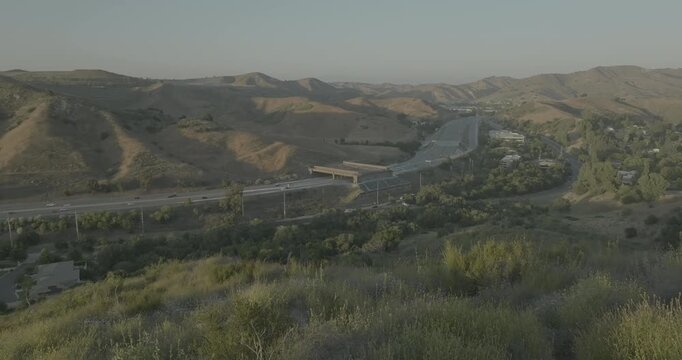 Aerial view of valley highway among rolling golden hills