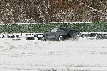 Black car drifts on icy track with snow clouds and tire rings © diczman