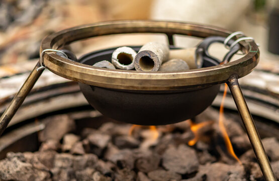 Old lead water supply pipes inside a metal melting pot outdoor close up