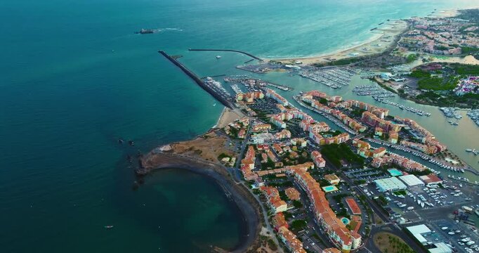Aerial view of picturesque Mediterranean marina in the town of Agde, featuring sailing yachts. A popular seaside resort in the south of France, known for its sandy beaches, yachting