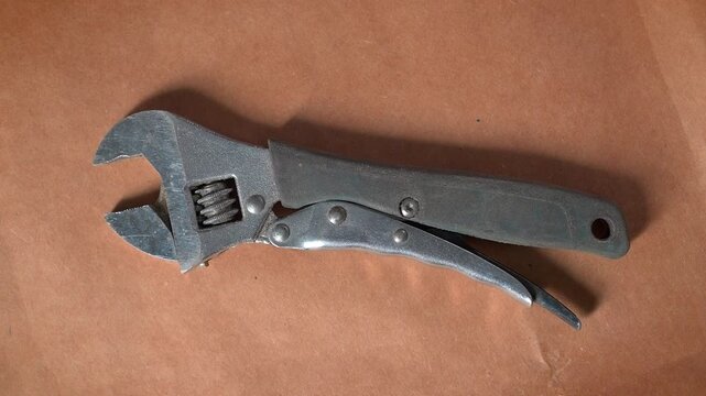 An used wrench on a brown paper surface. 