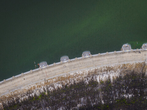 Aerial view of Zapora Zlotnicka dam showing the concrete wall structure and the deep green reservoir water in Zlotniki Lubanskie, Lower Silesian Voivod, Poland.