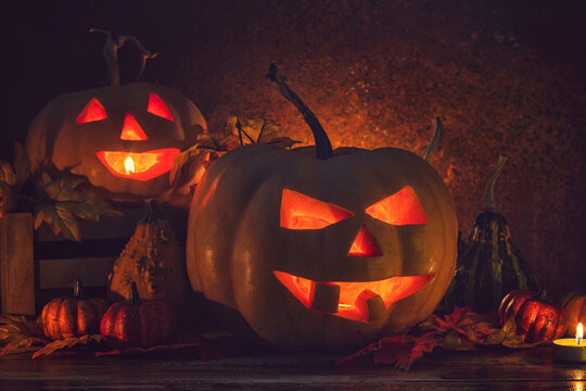 Jack O&rsquo; Lanterns glowing on the old rustic background