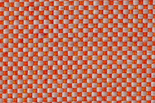 Close up of orange and white woven fabric texture with a classic checkerboard pattern