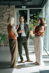 Business colleagues communicating in modern office hallway