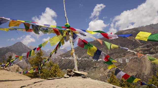 Colorful Buddhist prayer flags flutter gently above a sacred stupa in Nepal, creating a serene spiritual atmosphere in the Himalayan landscape. Traditional Tibetan flags display vibrant colors
