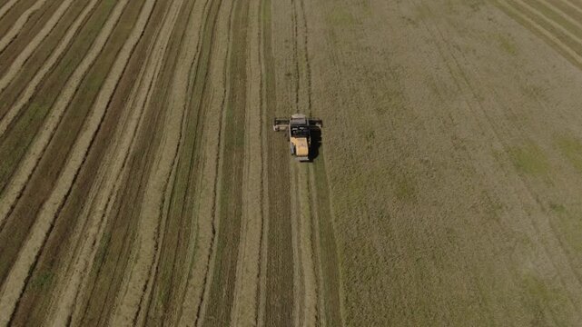 Drone rises and tilts down over combine, D-Log