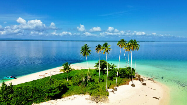 Aerial view of Manimbora Beach with white sand, turquoise water, and lush coconut trees along the coastline in Batu Putih, East Kalimantan, Indonesia.