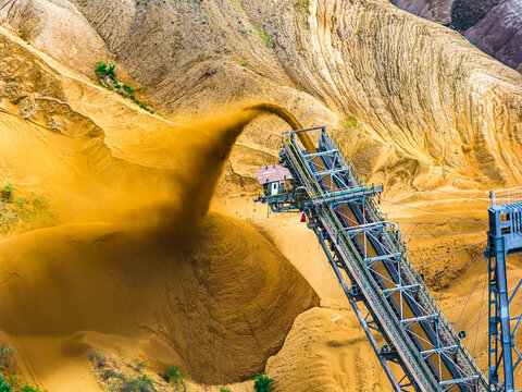 Aerial view of a massive bucket-wheel excavator at the Tagebau Hambach open-pit coal mine, discharging sand and earth onto a large pile Elsdorf, Nordrhein-Westfalen, Germany.