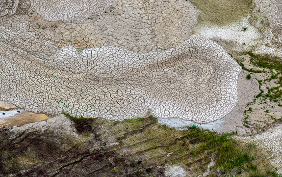 Aerial view of the cracked, dry earth patterns at Tagebau Hambach, showcasing the stark textures of the open-pit mining landscape in Elsdorf, Nordrhein-Westfalen, Germany.