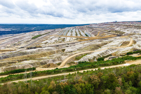 Aerial view of Tagebau Hambach open-pit mine showing vast terraced excavation layers, industrial infrastructure, and solar arrays in Elsdorf, Nordrhein-Westfalen, Germany.