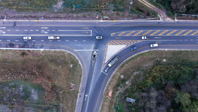Aerial view of a busy road intersection with vehicles navigating turning lanes and merging traffic, showcasing transport infrastructure in Johannesburg, Gauteng, South Africa.