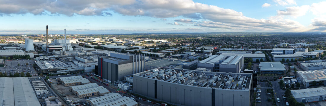 Aerial view of a large data center complex with cooling towers and industrial warehouses in the United Kingdom.