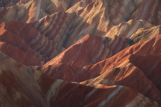 View of the colorful sandstone ridges and valleys of the Zhangye Danxia National Geopark, showcasing vibrant mineral layers and dramatic geological formations in Zhangye, Gansu, China.