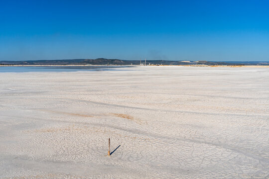 View of the dry, cracked surface of the Tailings Storage Facility under a clear blue sky in Padina, Varna, Bulgaria.