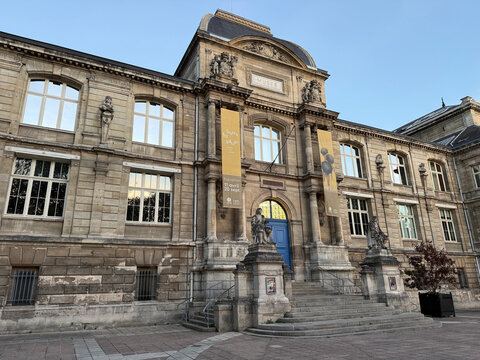 Stone facade of the Musee des Beaux-Arts de Rouen, featuring entrance steps, statues, a blue door and exhibition banners - Rouen, France - September 5, 2026