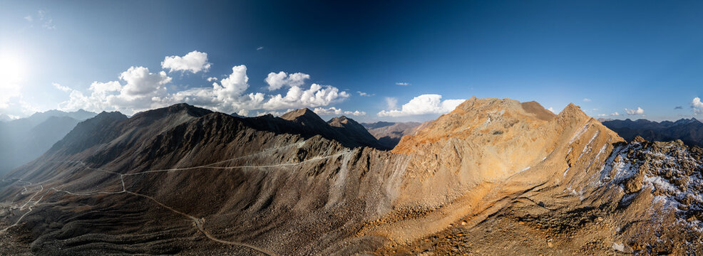 Aerial view of the rugged mountain peaks and winding paths of Supat Valley under a clear blue sky in Kohistan, Khyber Pakhtunkhwa, Pakistan.