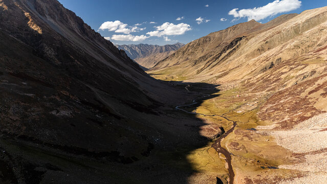 Aerial view of Supat Valley Kohistan featuring a winding river through a deep mountain valley with rugged slopes and rocky terrain in Kohistan, Khyber Pakhtunkhwa, Pakistan.