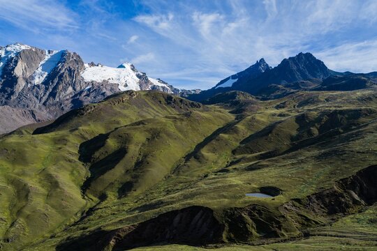 Aerial view of Hutun Ritty Glacier Rainbow Mountain trek Ausangate Glaciar del Nevado Inca Vinicunca Peru Peru aerial drone sunny morning blue sky morning clouds snow capped Peruvian Andes Red Valley.