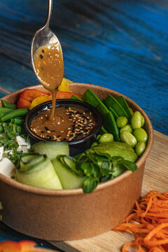 View of a fresh poke bowl with edamame, cucumber, and sesame dressing in Latvia.