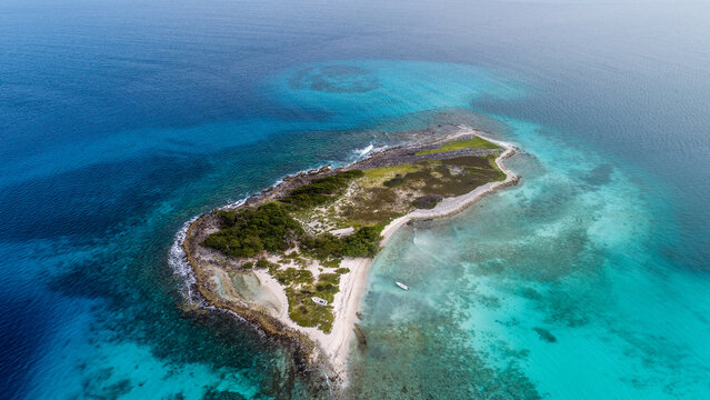 Aerial view of Los Roques archipelago with lush green vegetation, white sandy beaches, and small boats anchored in the turquoise Caribbean Sea, Los Roques, Dependencias Federale, Venezuela.