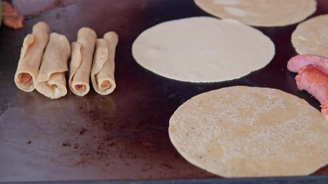 Mexican street food tacos and longaniza cooking on griddle