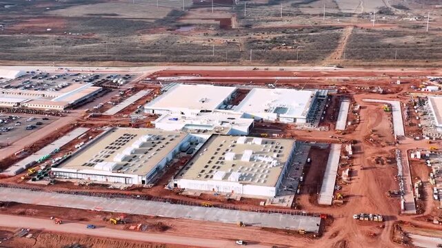 Aerial drone view of a large data center construction site in Abilene, Texas, with cranes, steel framework and heavy equipment on flat West Texas land