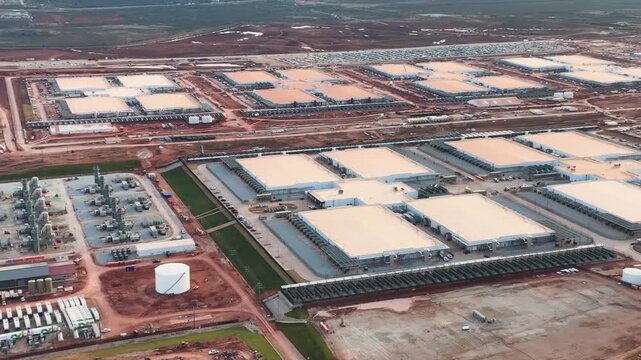Aerial drone view of a large data center construction site in Abilene, Texas, with cranes, steel framework and heavy equipment on flat West Texas land