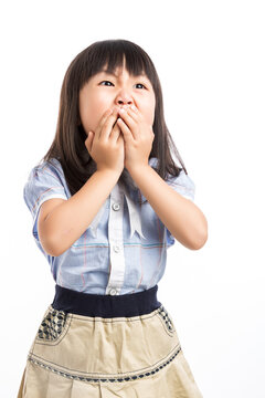 Little girl covering her mouth with hands, feeling shocked or keep a secret.