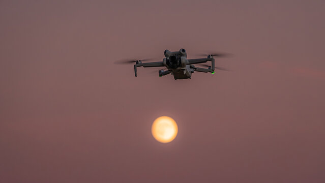 View of a drone flying in the sky against the setting sun in Vesancy, Auvergne-Rhone-Alpes, France.