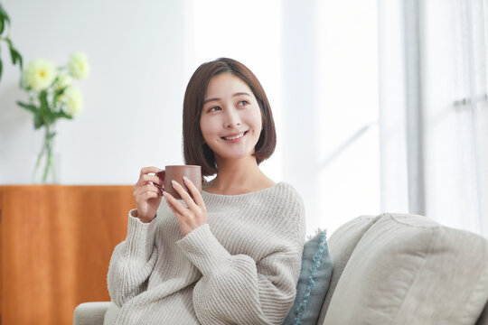 リビングでリラックスする若い女性