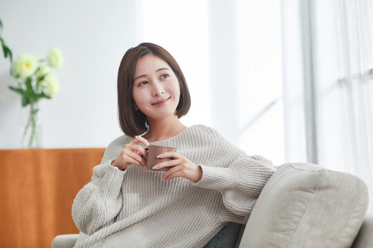 リビングでリラックスする若い女性