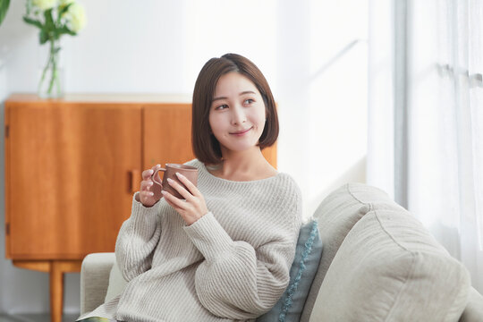 リビングでリラックスする若い女性