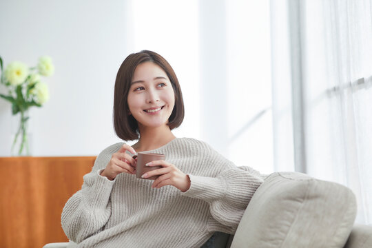 リビングでリラックスする若い女性