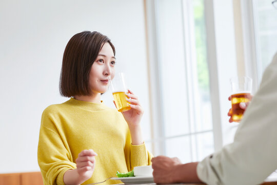 お酒を呑みながら食事をする女性と男性