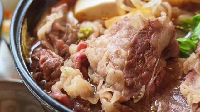 グツグツ煮え立つ黒毛和牛のすき焼き・肉鍋の超クローズアップ