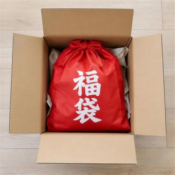段ボールに入った赤い巾着型の福袋の俯瞰