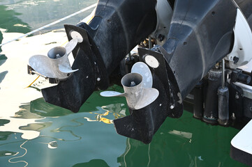 photograph showing dual boat engine propellers and outdrives over clean green sea water outdoors under natural daylight. © Drachenfutter
