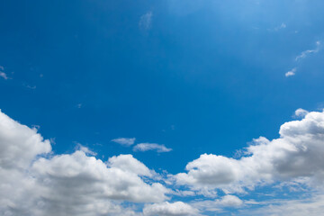 Fluffy clouds drift across a clear blue sky. © Shutter & Pixel Co.