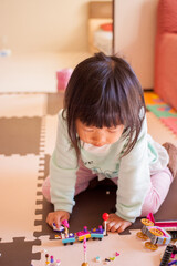 家でレゴのオモチャを遊んでいる幼児の女の子の様子 © zheng qiang