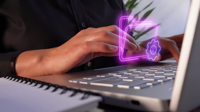 File and process management. Close-up of a professional woman's hands using a computer, showing a virtual icon of a folder and a gear.