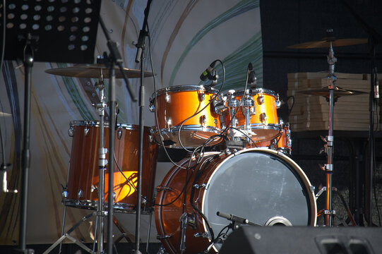 Professional orange drum kit set up on a concert stage ready for a live musical performance event