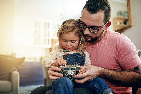 Camera, pictures and man with child, lounge and bonding with daughter in house, vintage and weekend. Family, home and photography with retro tech, kid and hobby with dad, growth or skill development