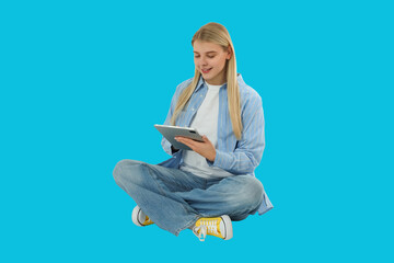 Young woman enjoys browsing on tablet while sitting comfortably © Atlas