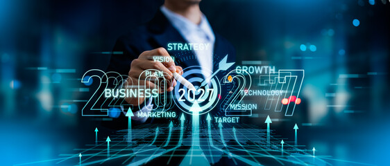 Businessman pointing at upward arrow and target.Road to successful and Profit of growth in year 2027.Business target growth and development plan,Analyzes trend,Business strategy and goal 