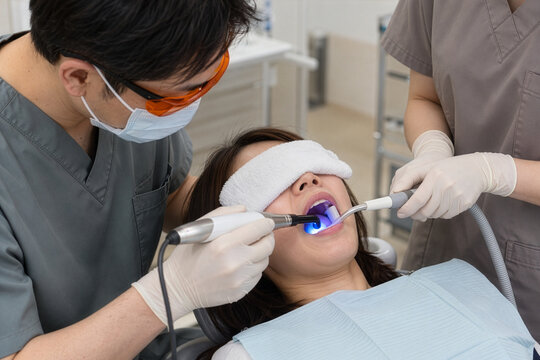 Dentist curing a composite filling with a blue light